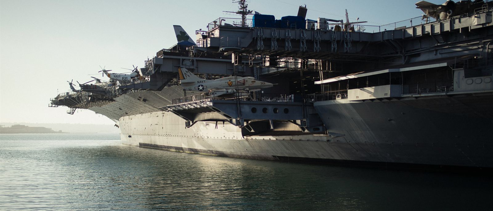 An aircraft carrier at anchor in coastal haze